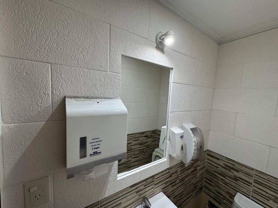 Baño con paredes revestidas con placas texturadas blancas