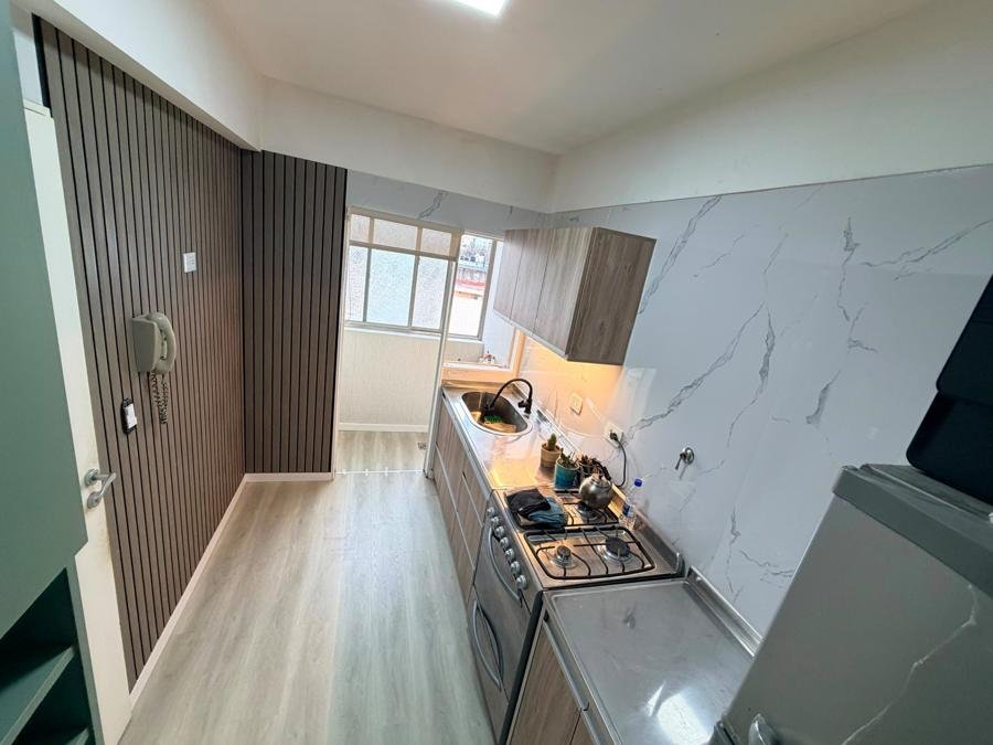 Cocina con wallpanel, placas símil mármol y piso símil madera