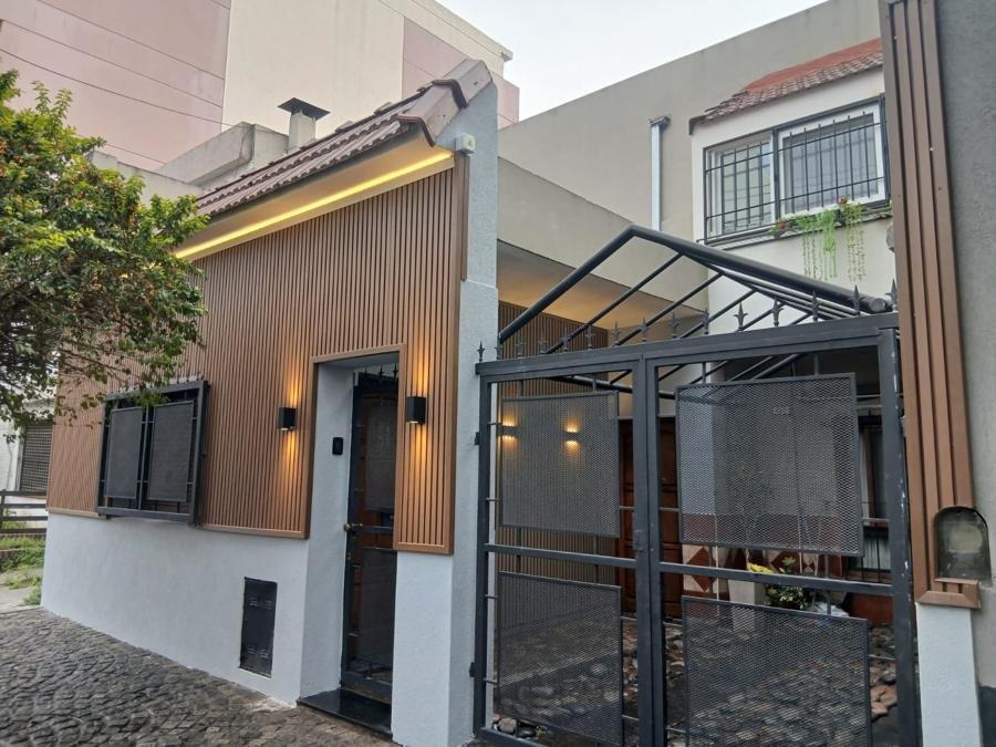 Frente de casa revestido con wallpanel exterior varillado y revestimiento texturado gris